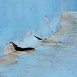 پوسته شدن رنگ آبی استخر بتنی به‌دلیل رطوبت و ضعف زیرسازی